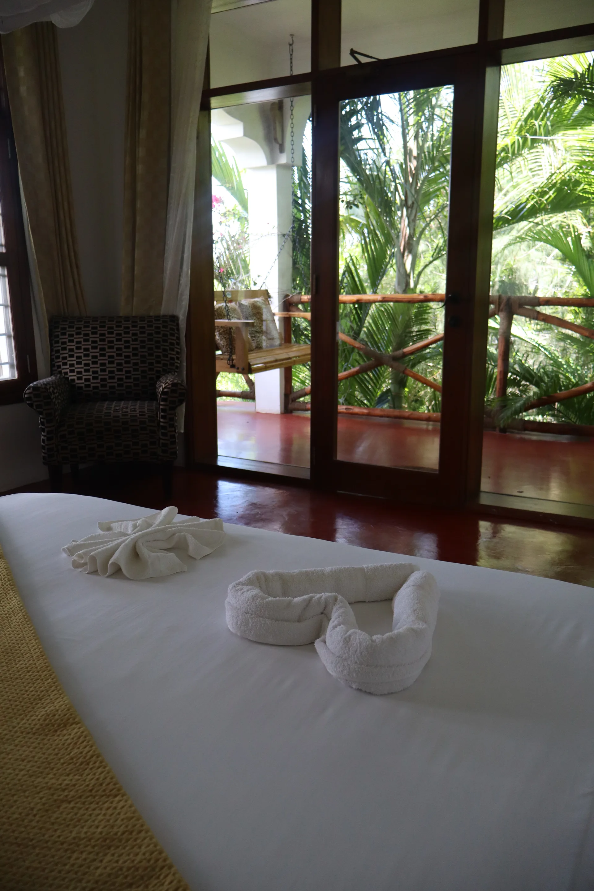 Bedroom with canopy bed and balcony view at Hamia Zanzibar