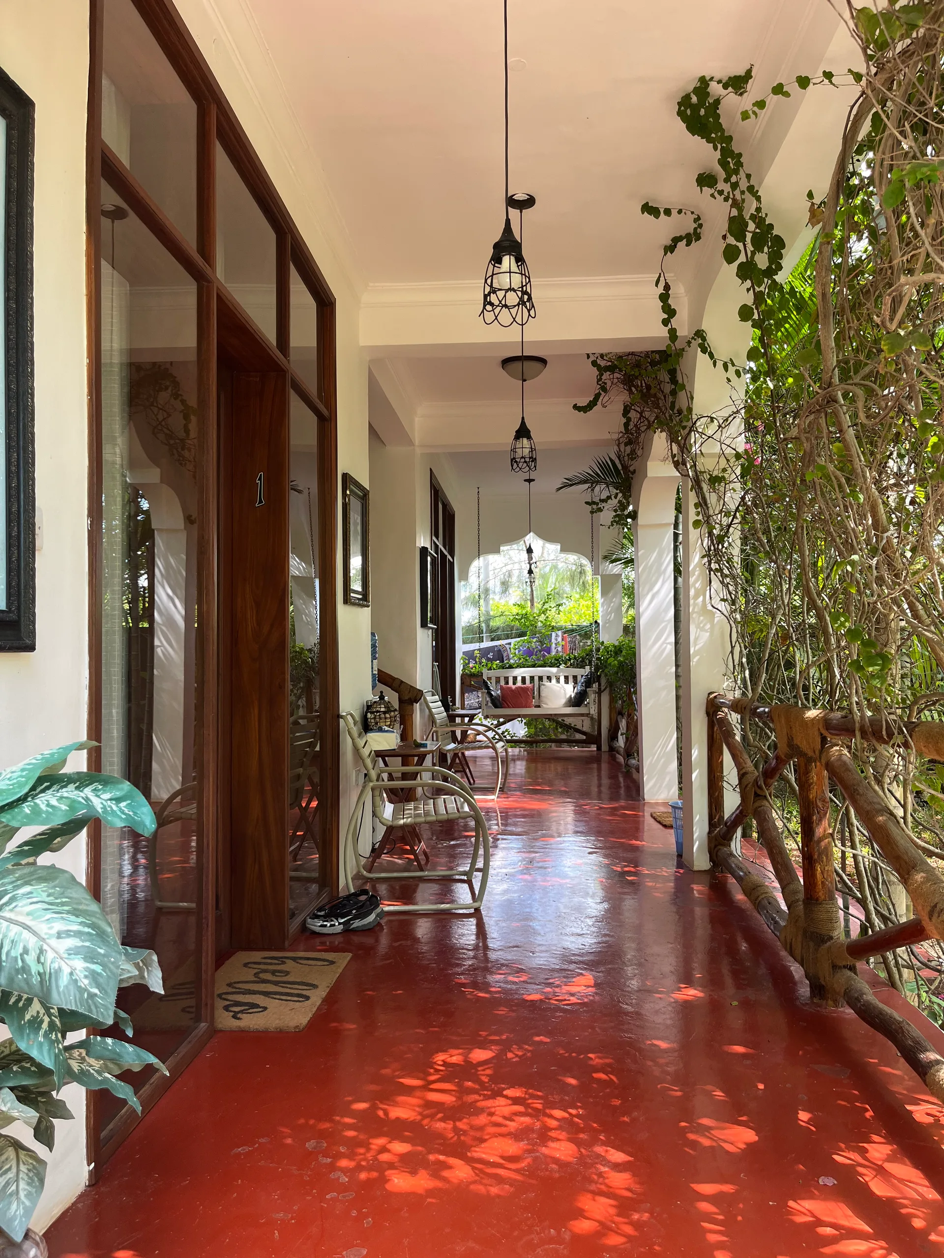 Red-polished veranda with pendant lights at Hamia Zanzibar