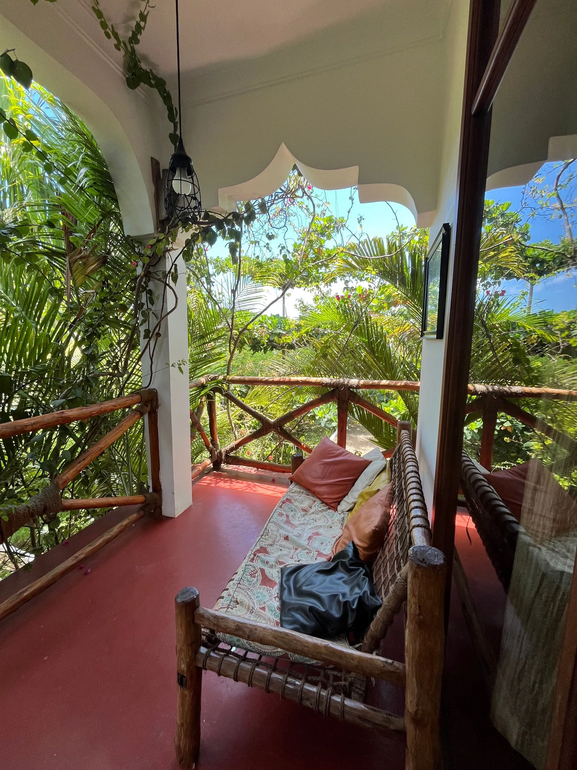 Private bedroom balcony at Hamia Zanzibar with a wooden railing looking out over the palms